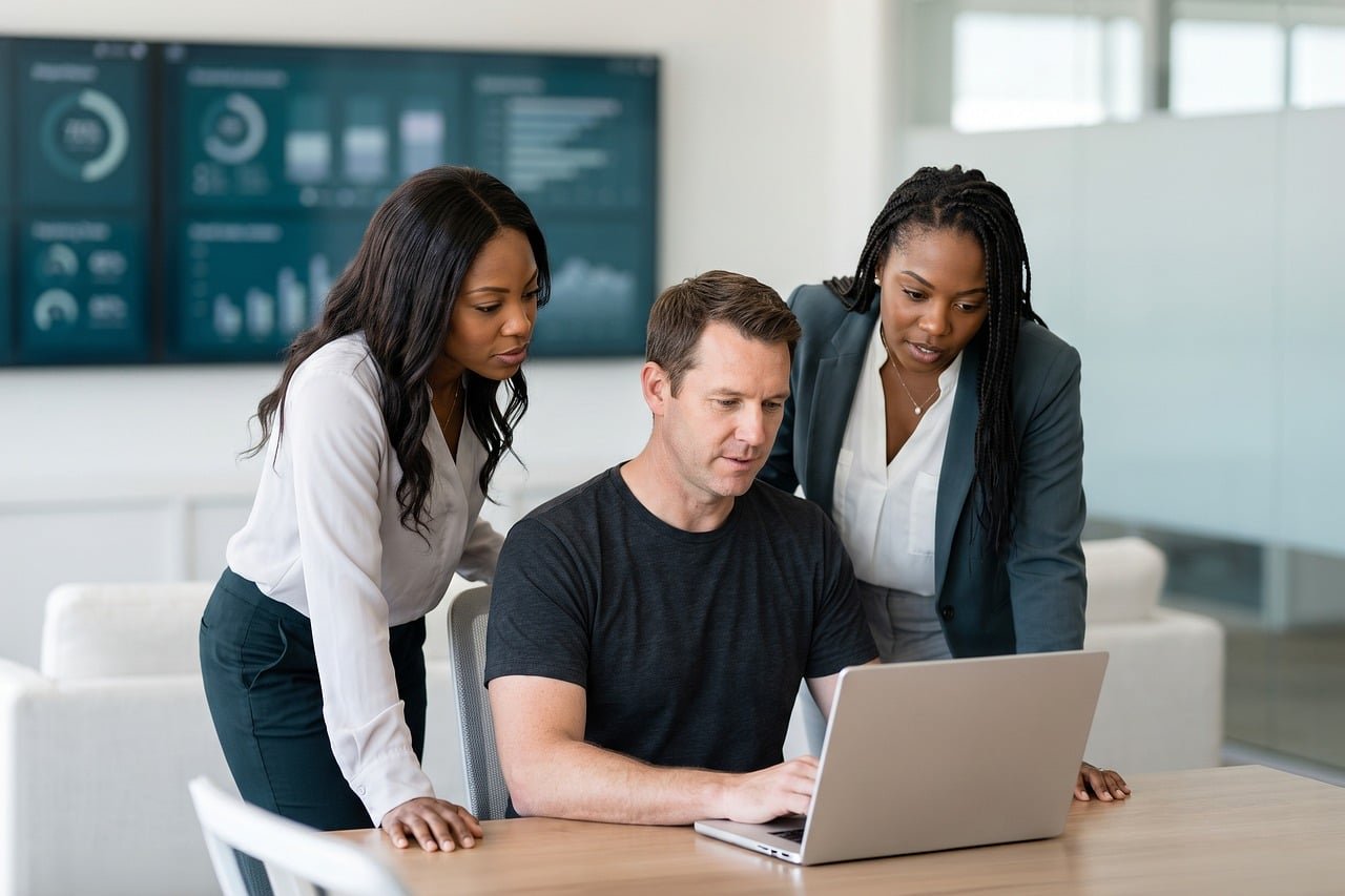 Three colleagues reviewing campaign results on a laptop